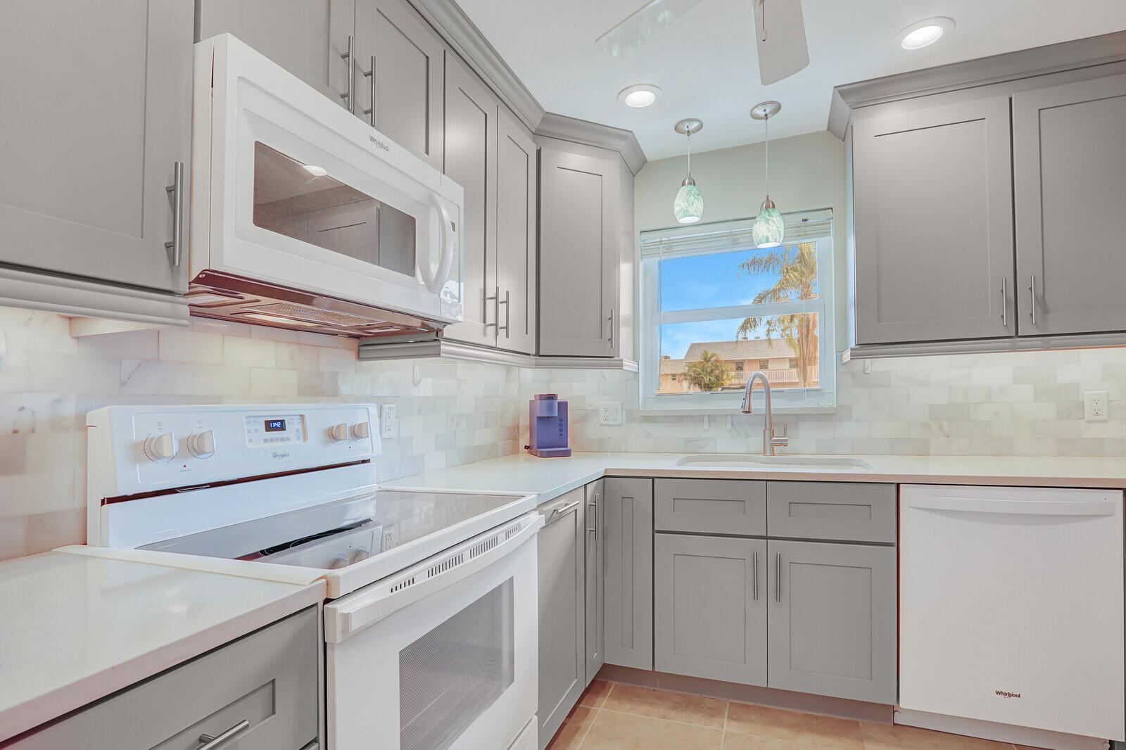 Beautifully updated 2-bedroom, first-floor condo that's move-in ready and fully furnished! This clean and well-kept unit offers easy access and a prime spot in Building 2. All new remodeled kitchen boasts custom cabinets, quartz countertops, under cabinet LED lights, new appliances & new pendant lights. Enjoy peaceful views from the screened-in patio, which includes an extra storage closet. Inside, you'll find stylish tile floors & impact windows. Both bedrooms feature spacious walk-in closets for plenty of storage. This 55+ community is packed with amenities--enjoy free golf (included in your HOA), a pool, tennis courts, clubhouse, shuffleboard, bocce, and more. Located right next to Jonathan Dickinson State Park. Close to restaurants, shops, golf, I-95 and The Beach
