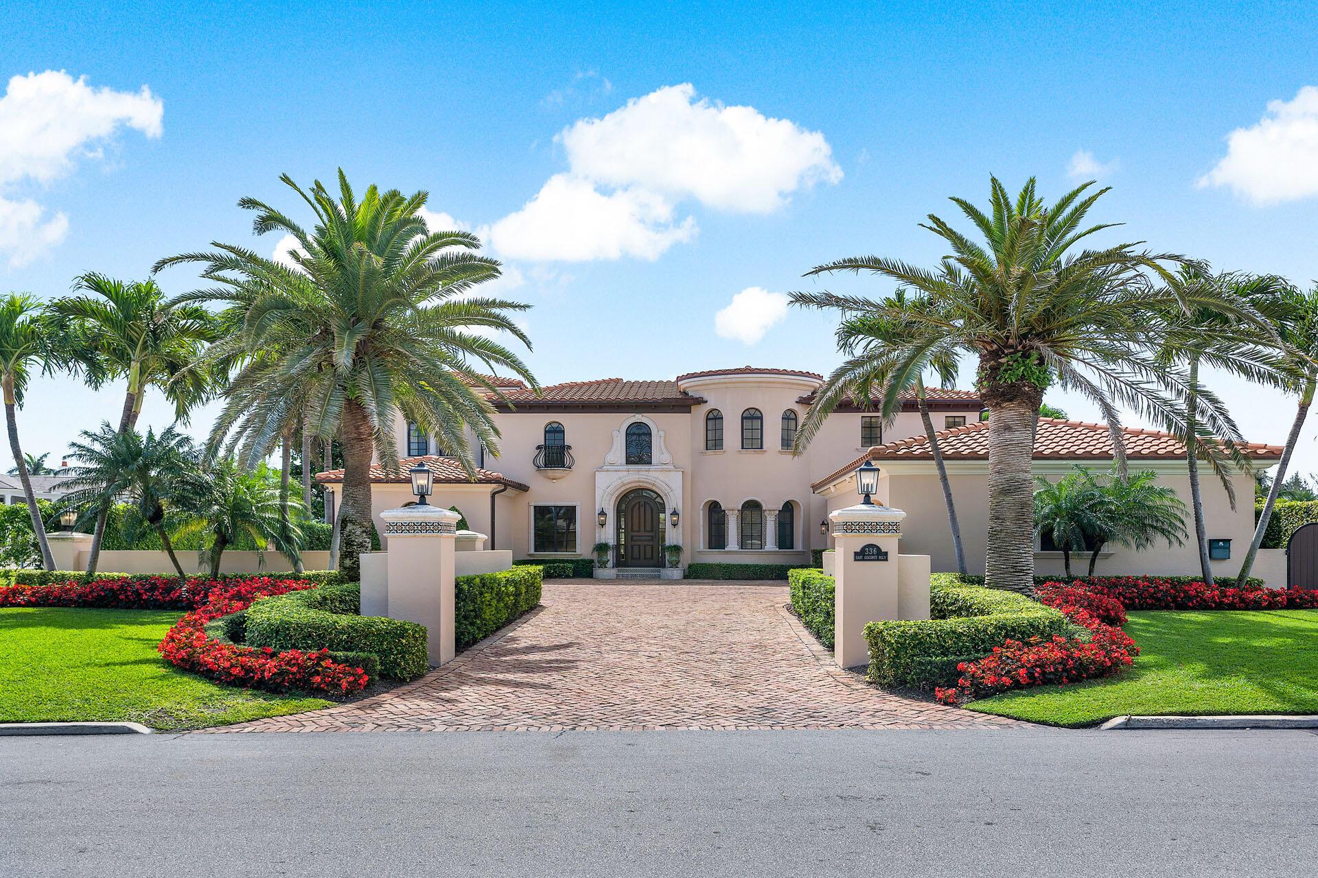 Welcome to luxury living in the prestigious Royal Palm Yacht & Country Club. This trophy property on East Coconut Palm Road is nestled along 111' of the picturesque Buccaneer Palm Waterway. The waterfront estate features 5-bedrooms + office, 5 full and 2 half bathrooms, and a 4-car garage. As you approach the meticulously landscaped grounds, a grand walled entrance sets the tone for what lies within. Marvelous hand-carved finishes, designer wall coverings, and incredible architectural details lead you to over 7,500 sq ft of living and entertaining spaces. The gourmet kitchen is a chef's dream, featuring a large island, premium appliances, and exquisite finishes. Adorned with an entertainer's bar, rich wood built-ins, and a cozy fireplace, this club room is perfect for hosting