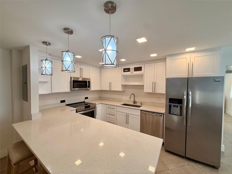 Available for 6 Months! Fully renovated ground-floor corner 1 bed, 1.5 bath condo in the luxurious Kings Point community. Open-concept layout with smooth ceilings (no popcorn), new LED lighting, and ceiling fans throughout. Updated kitchen with stainless steel appliances, white shaker cabinets, and quartz countertops. Renovated bathrooms with new vanities; primary bath features a walk-in tiled shower with glass door and walk-in closet with custom wood shelving. Upgrades include new electrical panel, new plumbing, and tankless water heater. Enclosed patio with impact windows, A/C, and full-size washer and dryer. Conveniently located near the Flanders main entrance and clubhouse. Kings Point offers golf, pools, tennis, fitness center, theater, café, and bistro.