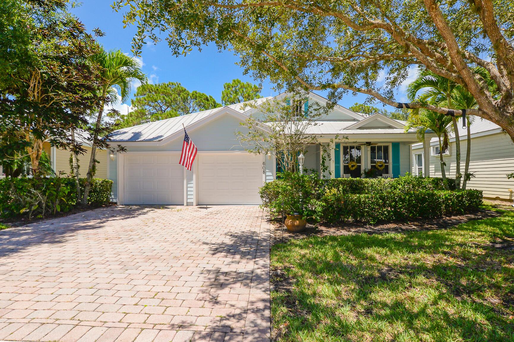 Step into the sun-drenched serenity of this Key West-style gem at 608 NE Canoe Park Circle in the renowned River Place community of Port St. Lucie. Nestled against a lush nature preserve, this CBS built one-story sanctuary blends casual elegance with tropical charm. Metal roof and classic fiber-cement siding, exuding breezy charm and enduring durability. The interior invites you in with soaring 10-ft ceilings, crown molding, and updated flooring that flows seamlessly into an open-plan kitchen equipped with stainless-steel appliances and luxurious granite countertops. The main suite is a peaceful retreat, featuring dual walk-in closets, a spa-like dual-sink vanity, expansive walk-in shower, and a dreamy garden tub to soak and unwind in true island-fashion. A screened lanai backs onto a