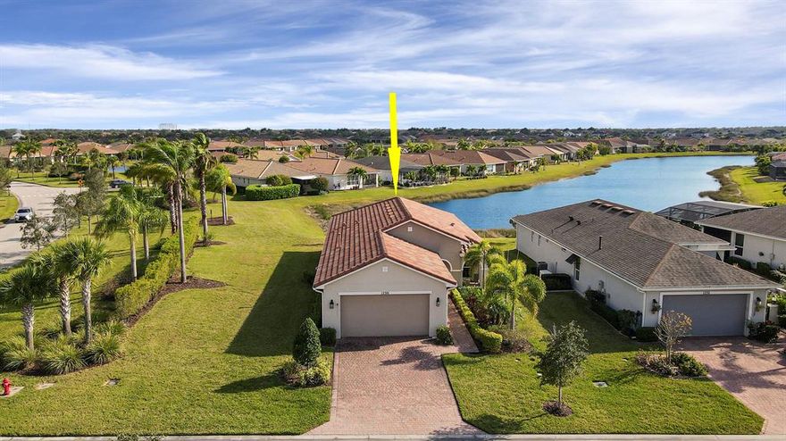 Wake up to GORGEOUS LONG LAKE VIEWS every day in this Andalucia floor plan on a LAKEFRONT CORNER LOT in the 55+ community of Vitalia. Built in 2017, this 2BR+Den/2BA/2CG home features IMPACT GLASS WINDOWS & DOORS, a barrel tile roof, decorative glass front door, charming front porch, screened and covered patio viewing the lake, tile flooring through the living areas, carpeted bedrooms, gas appliances and more. The kitchen opens to the living area and features espresso colored cabinetry, granite counters, SS appliances, large pantry cabinet and spacious center island with an abundance of storage. The sizable master suite has a huge window that frames the serene lake view. Oversized walk-in closet and spa-like ensuite with dual sinks and large walk-in shower make this bedroom a true oasis. Guest bedroom and den share a hall bathroom. Laundry room with upgraded washer & dryer as well as cabinetry for storage. The garage has a utility sink as well as finished garage floor. Separate furniture package is available for those looking for an easy move. HOA dues include basic cable, internet, alarm monitoring, security, lawn care, common area maintenance and access to the community amenities. Vitalia is a resort style 55+ community with plentiful amenities including beautiful pool, clubhouse, pickleball & tennis courts, putting green, exercise rooms, library, social clubs and more. Located just a short bike ride from charming Tradition town square with shopping, dining and events. Conveniently located to interstates, hospitals, beaches and airpots. Wonderful opportunity to own a slice of paradise. Call today!