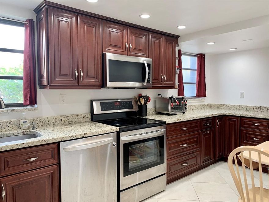 Beautifully remodeled first floor corner condo with large white tile throughout and plenty of natural light. Remodeled kitchen with great custom storage, granite countertops, s/s appliances and recessed lighting. Two large bedrooms, two full baths, the spacious primary suite offers a full bath with a walk-in shower, walk-in closet and an additional large closet. Hurricane impact windows and a hurricane impact steel rated panel front door.  Full size stacked washer/dryer inside your condo and an enclosed patio with natural pebble-stone flooring. Heated swimming pool, bocce and a clubhouse in this cozy age restricted community. Great location, near all the restaurants, shops, parks and entertainment. Only 1.5 miles to the beach with oceanfront dining, schedule a tour today!