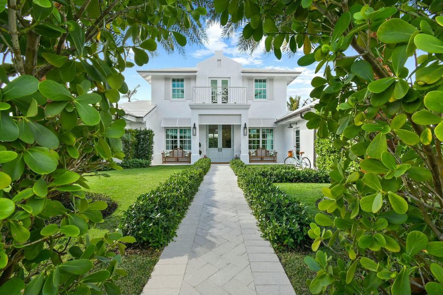 Step into a rare opportunity to own one of the most remarkable interior homes in Jupiter Inlet Colony--a luxurious sanctuary that seamlessly combines high-end design with timeless coastal charm. This home underwent a complete transformation in late 2021, resulting in a masterpiece of refined elegance. The white exterior, inspired by Cape Dutch architecture, is adorned with Bevolo gas lanterns, towering Sylvester palms, lush Bermuda grass, and meticulously maintained Clusia hedges, creating an inviting yet private oasis in this sought-after beachside community. Every element, from the custom Chippendale stairwell to the exquisite Urban Electric and Palecek lighting, has been thoughtfully curated to offer a one-of-a-kind coastal