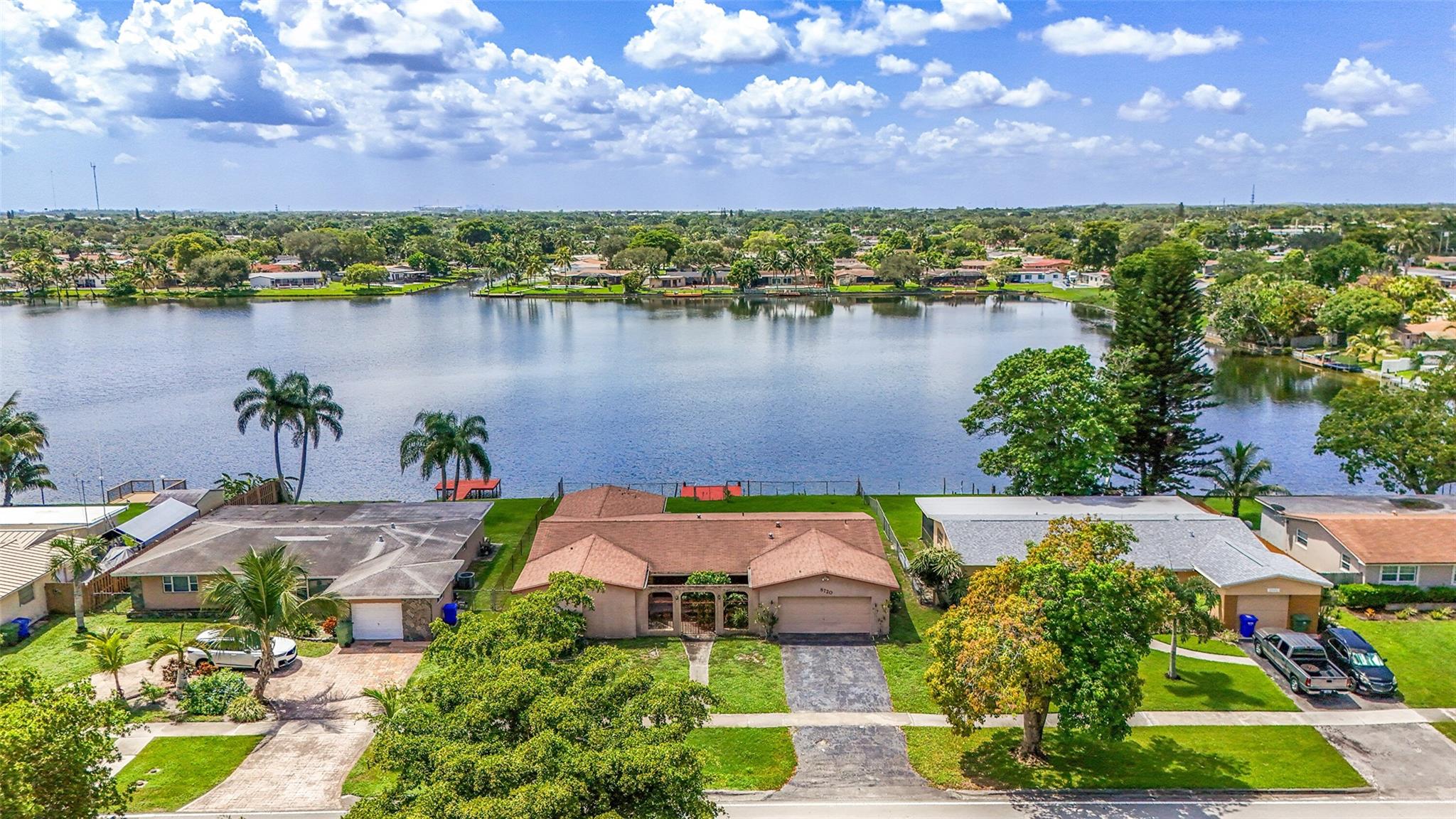 This home is the perfect blank canvas for someone ready to bring their vision to life. Every room needs updating, making it an ideal opportunity for buyers who want to remodel & design according to their own style. Inside: a large eat-in kitchen, spacious master bedroom, formal living & dining room, & a generous family room. Step outside & you’ll be captivated by the property’s standout feature—a massive lake with breathtaking views. The fenced backyard includes a private dock where you can fish, relax, or launch small water adventures. Whether you’re watching the sunset or enjoying a quiet morning coffee, the lakefront setting creates an unmatched sense of serenity. This property is a rare chance to create your dream home in a highly desirable location. Elementary school across the street