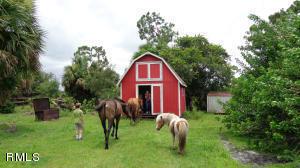 Buy 20 Acre ranchette available with a small mobile storage home, a large pole barn with 4 stalls, and a separate red barn workshop, 8.5 Acres of wetland. Pond for cattle, gated and fenced. Off 714, only 12 miles West of I95. Do you know that Indiantown (i-Town) is only 30 Minutes from several Counties? Only half an hour to West Palm Beach, and to Stuart. Access to I-95 and Turnpke plus 3 major airports. Mailing address is Okeechobee, FL 34974. It is in Martin County. Taxes were higher than neighbors and do not show any AG exemption this last year. Lots of peace and quiet! Most importantly there is NO Homeowners Association.