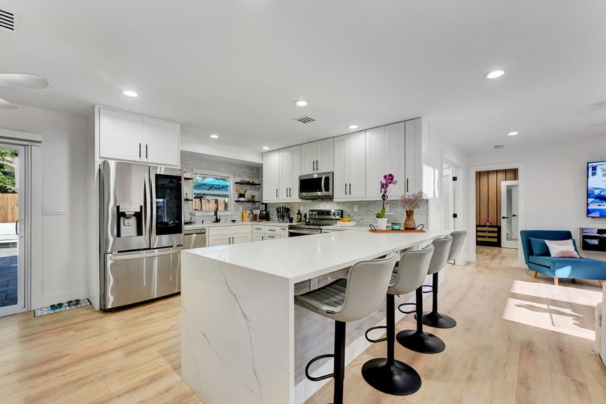 Fully reimagined in 2023, this stunning residence was taken down to the studs and rebuilt with exceptional attention to detail and quality throughout. Featuring 4 bedrooms, 2 baths, and a 2-car garage, the home offers a seamless blend of luxury and functionality. Upgrades include impact windows and doors, closed-cell foam insulation, and designer LED lighting throughout. The chef's kitchen is outfitted with real wood, soft-close cabinetry, quartz countertops, and premium stainless steel appliances. Custom closets provide abundant storage. Smart home features include a WiFi-enabled thermostat, Rain Bird irrigation, Sonos, and AquaLink pool heater/chiller for year-round enjoyment. Backyard is totally private. Ideally located just 2 miles from Atlantic Ave and 3 miles from the beach.