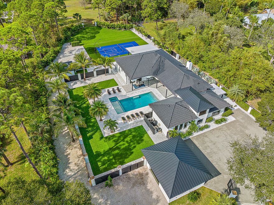 Come experience the tranquility of this sprawling 2.5+ acre Jupiter estate! The property was totally reimagined with renovations just completed in December of 2023. The achieved vision was to create an airy, free-flowing experience that seamlessly unifies indoor & outdoor living spaces. This house is ready for entertaining with 5 en-suite bedrooms, including a separate in-law suite, plus fully detached guest house. The outdoor living areas exude privacy & recreation, featuring over 2,000 sq ft of covered lanais, a heated saltwater pool & spa, outdoor kitchen, & sports court with pickleball, basketball, & shuffleboard. Located near all amenities, it is the perfect place to call home for those who value privacy, luxury, & an active lifestyle. Being sold furnished for your convenience!