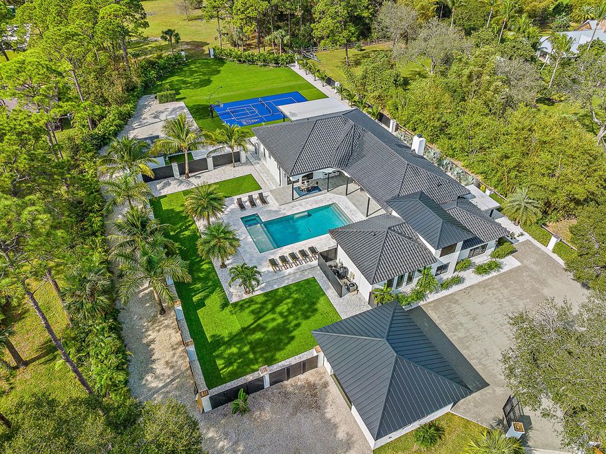 Come experience the tranquility of this sprawling 2.5+ acre Jupiter estate! The property was totally reimagined with renovations just completed in December of 2023. The achieved vision was to create an airy, free-flowing experience that seamlessly unifies indoor & outdoor living spaces. This house is ready for entertaining with 5 en-suite bedrooms, including a separate in-law suite, plus fully detached guest house. The outdoor living areas exude privacy & recreation, featuring over 2,000 sq ft of covered lanais, a heated saltwater pool & spa, outdoor kitchen, & sports court with pickleball, basketball, & shuffleboard. Located near all amenities, it is the perfect place to call home for those who value privacy, luxury, & an active lifestyle. Being sold furnished for your convenience!