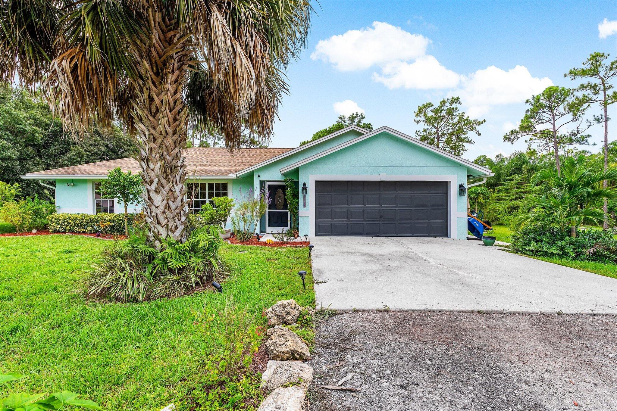 NEW ROOF - NEW A/C!Great location in Loxahatchee for this charming 3BR home! There is beautiful wood like tile flooring in main living areas and primary B/R, vinyl in in secondary bedrooms Granite counters in kitchen, with SS appliances - and a bar to sit around. 2 screened patios - one for entertaining, and a private one off of the primary bedroom! The garage floor has been redone with an epoxy finish! Some of the windows and doors on the south side of the home are impact. The yard is fully fenced, no pond, a shed, and on a paved road - close to Seminole Pratt (but far enough away so no road noise). Exterior was painted in 2024, and there is a security system with cameras.Come and view today!This is a cute home ready for new owners!