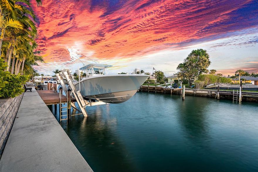 Updated exceptional contemporary waterfront home featuring 4 bedrooms, den, 3.5 baths.  Boaters paradise with 100' of frontage on an extra wide canal and 20k lb lift.  Desirable south exposure.  Newer standing seam metal roof, hurricane impact windows and doors, 4 AC units 2016, tankless hot water heater and natural gas full house 22kw generator.  Walk inside to cathedral ceilings and a bright open floor plan with no shortage of natural light.  Glass wood burning fireplace separates the dining and great room.  Chef's kitchen with modern white cabinetry, stone counters, glass tile backsplash, Wolfe gas range and breathtaking views.  Upstairs master suite with balcony and luxurious master bath and walk in closet.