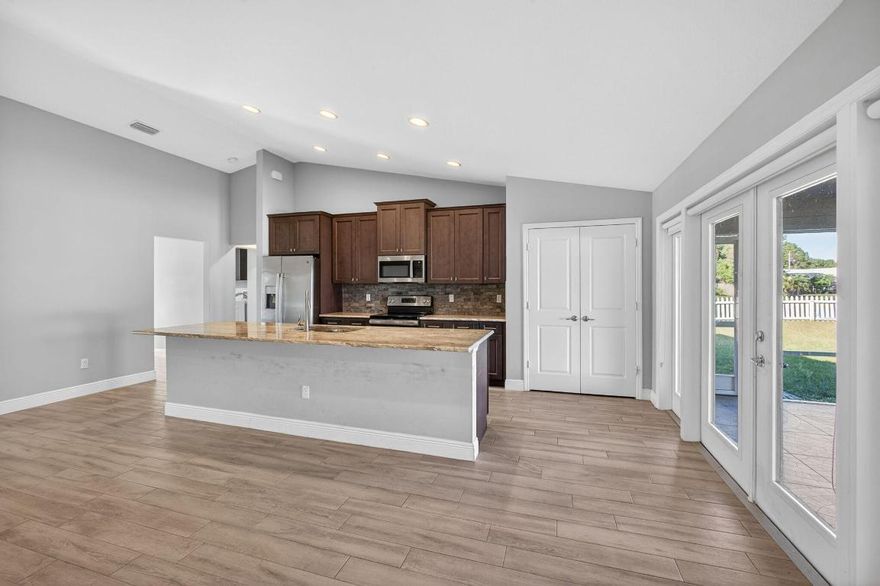 This elegant 4-bedroom, 3-bath residence, built in 2021, offers refined living with breathtaking lake views and a thoughtfully designed split floor plan. The home features a spacious den, formal dining area, and an open layout that blends comfort with sophistication. Step outside to a beautifully screened patio accented with striking mosaic tile, creating the perfect setting to relax and enjoy serene water views. The expansive yard, extended driveway turnaround for added convenience and safety, and the absence of an HOA provide a truly effortless lifestyle. Ideally positioned near the best of Jensen Beach, Port St. Lucie, and Fort Pierce, this exceptional property seamlessly combines modern design, privacy, and natural beauty.