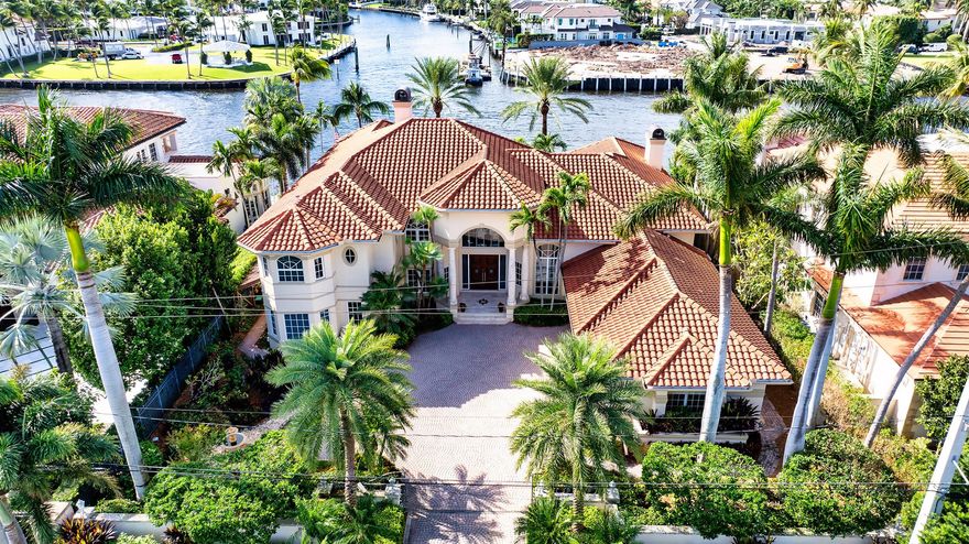 Extraordinary and unobstructive sweeping views of the Intracoastal Waterway and Grand Canal to Royal Palm Yacht & Country Club highlight this gated Mediterranean-inspired estate residing on 100+/- feet of shoreline. Majestic landscaping adorns the impressive entrance, custom paver motor court and the resort-inspired outdoor entertainment space that stretches across the entire water side of the residence. The luxurious pool with spillover spa is framed by a grand loggia and tiered terraces served by a summer kitchen/bar.Greeting guests with a dramatic double door entry, the five-bedroom residence flows flawlessly to host gracious entertaining and capture the beauty of the endless glistening waterway and colorful tropical garden views from all major rooms.