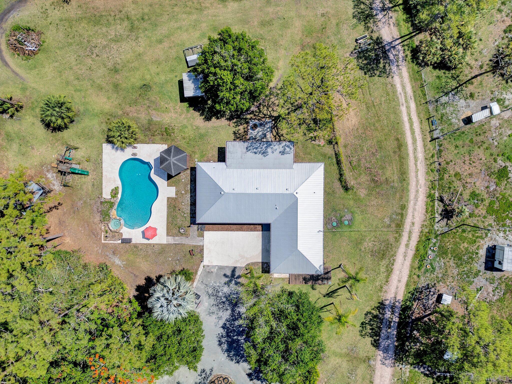 Coastal Farmstead Retreat - Just 10 Miles from the Beach! Welcome to your dream homestead-a versatile 5-acre property in the sought after Palm City Farms. A perfect blend country charm with coastal convenience, this unique estate offers space, flexibility, and income potential all in one. The main home features 3 bedrooms and 2 bathrooms, providing comfortable everyday living. Attached is a stylish and private 1 bed / 1 bath 'Boho Bungalow' in-law suite, perfect for guests, rental income, or extended family. You'll also find a separate 2 bed / 1 bath guest house, giving you even more options for multi-generational living or Airbnb potential. For hobbyists, entrepreneurs, or outdoor enthusiasts, the property includes a 6-bay shop with a lift,