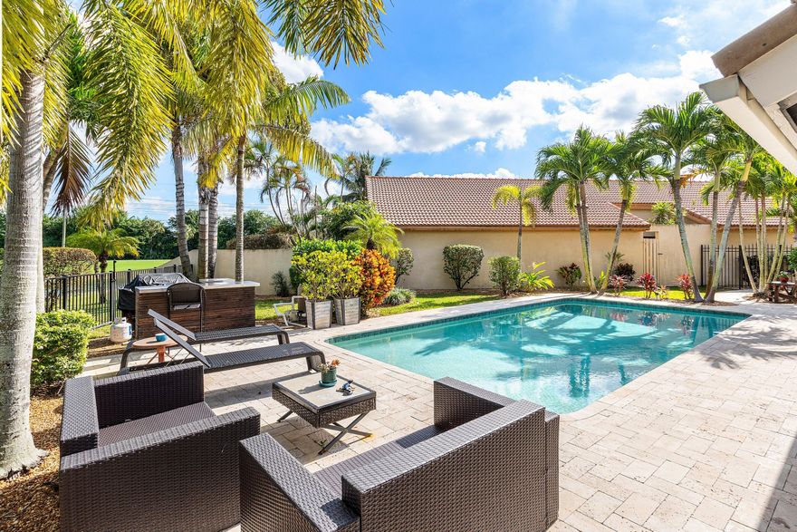A patio home that truly lives large. Situated on a quiet cul-de-sac and positioned on the widest part of the pie-shaped lot, this unique patio home offers exceptional space, privacy, and views. The split two-bedroom floor plan includes a convertible den/office—ideal for working from home or hosting guests. Set on an expansive 8,000+ square foot lot, the property features a large pool and a fenced, resort-style backyard surrounded by lush tropical landscaping and beautiful palms, creating a private oasis. Enjoy serene lake views along with partial golf course views as you watch golfers tee off in the distance. Located in Boca Woods Country Club, one of the area's premier golf communities, residents enjoy an exceptional hole-to-home ratio with two championship courses.  The Rees Jones-redesigned Woods Course offers a fresh challenge, while the Lakes Course provides equally beautiful and versatile play, accommodating golfers of every skill level. The recently completed state-of-the-art Fitness, Spa, and Physical Therapy Center features personal trainers, group classes, Pilates reformers, and multiple studio programs. The vibrant clubhouse offers two restaurants, bars, card rooms, and game rooms for an active social lifestyle. Golfers will appreciate the outstanding practice facility featuring Top tracer technology on the driving range, excellent clinics, a highly regarded professional staff, and plenty of opportunities to find games with players at your level. Racquet sports enthusiasts will enjoy 4 pickleball courts and 7 Har-Tru tennis courts, supported by professional instruction, inter-club competition, and a full calendar of social events. This property blends privacy, water and golf views, and world-class amenities—offering one of the finest lifestyle opportunities in Boca Woods.