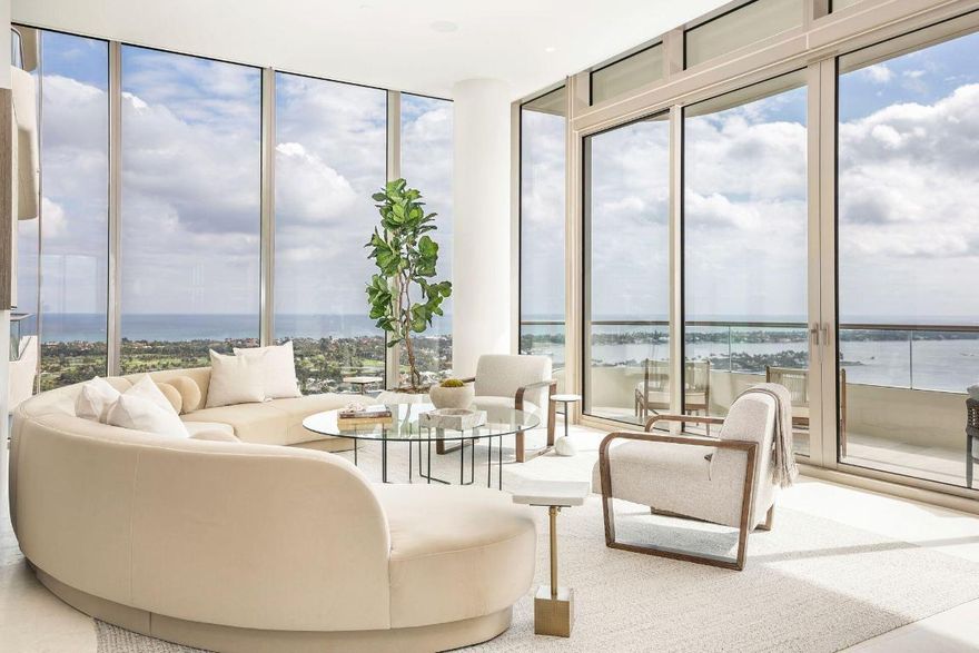 Perched high above S Flagler Drive, waterfront Penthouse G at La Clara lives like a house in the sky offering uninterrupted views of the Atlantic Ocean, Palm Beach Island, Intracoastal, and downtown skyline. A foyer with soaring ceilings leads into a lounge and formal living room framed by floor-to-ceiling water views. Vistas continue through the dining room to an expansive family room and gourmet kitchen, showcasing Miele appliances, gas cooktop, butler's pantry, and oversized island with seating. Designed for effortless indoor-outdoor living, the sprawling covered terrace flows seamlessly from the family room, creating an ideal setting for sunset cocktails, intimate dinners, or elevated entertaining with a panoramic backdrop. The luxurious primary suite offers complete privacy with... ...with a South-facing balcony and views stretching from East to West. Through a bonus den/office connects two private guest suites with ensuite baths. Additional features include a laundry room, powder room, storage space, and 3 premium garage parking spaces. Residents of La Clara enjoy world-class amenities, a state-of-the-art waterfront fitness center, resort-style pool, 24/7 valet, private cinema, and onsite guest suites - creating a lifestyle that is unmatched.