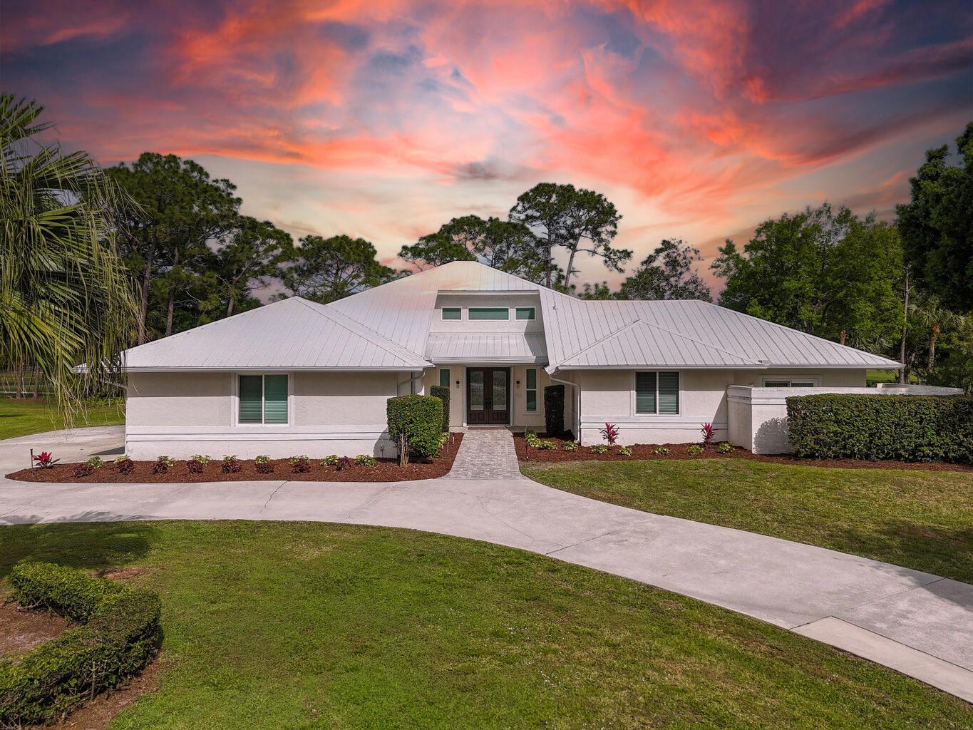 This stunning, move-in ready home sits on a 1/2-acre lot overlooking the 2nd hole of the Legacy Golf Course. Recently updated throughout, it features a 2018 metal roof, PGT WinGuard impact windows, hurricane-rated garage door, and 24x24 porcelain tile flooring for a modern, cohesive look. The fully renovated kitchen boasts Bosch appliances, granite counters, custom cabinetry, and a built-in beverage center with wine cooler. All bathrooms were redesigned with seamless glass showers and custom cabinetry, while the oversized laundry/hobby room offers 15.5 feet of storage with granite counters. New A/C units (2021/2022), updated electrical panel, and whole-house water filtration system add value and peace of mind. Enjoy expansive parking, a 3-car garage, and breathtaking golf views. PGA