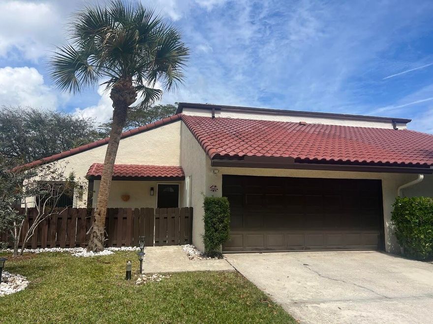 Stunning remodeled two-story townhome with a two-car garage in East Boca Raton. This home features a gourmet kitchen equipped with quartz countertops, custom cabinetry, stainless steel appliances, and an island. The spacious living room boasts vaulted ceilings, skylights, a stone fireplace, and tiled floors. Additional highlights include modern ceiling fans, glass pendant fixtures, LED lighting, and stylish bathroom vanities, mirrors, and showers. **There are two master suites: one upstairs with a sun deck and one downstairs with a patio, both featuring engineered hardwood floors..** Enjoy the sunshine and entertain guests in your super large fenced yard, complete with tropical trees and two patios. Dogs are allowed (no aggressive breeds or cats), and lawn care service is included.  No HOA
