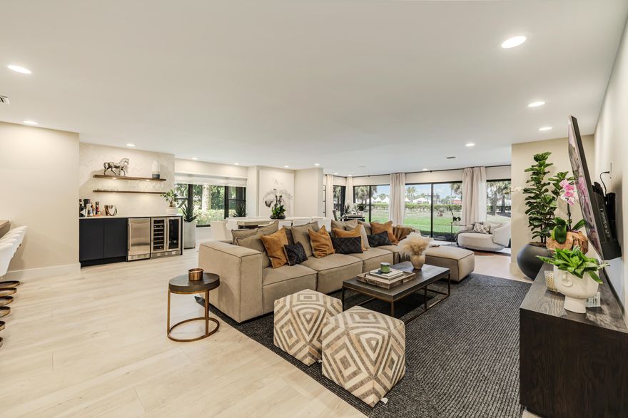 This magnificent, fully renovated condo showcases luxury and modern elegance. The spacious three-bedroom, three-bathroom residence offers breathtaking water views and overlooks picturesque horse grounds, creating a peaceful and unique setting in the heart of Wellington.  The open-concept living area serves as the centerpiece of the home, featuring floor-to-ceiling windows that fill the space with natural light while capturing panoramic views of the surrounding landscape. The living room is tastefully appointed with designer furnishings and a state-of-the-art entertainment system with a large flat-screen TV.  The gourmet kitchen is a chef's dream, complete with top-of-the-line stainless steel appliances, ample cabinetry, and a layout designed for both everyday living and entertaining.