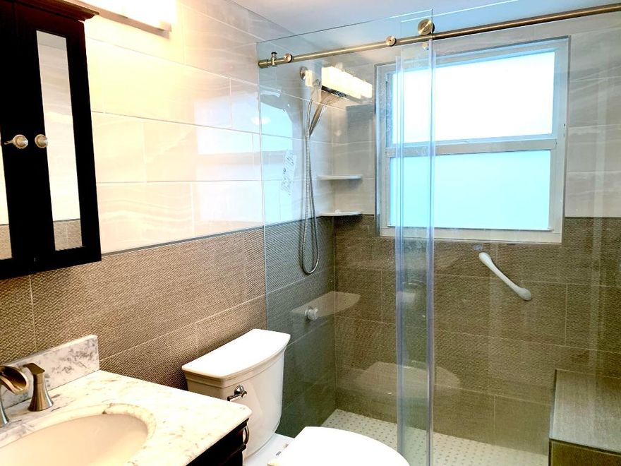 **CORNER** Light and Bright FIRST FLOOR Apartment, North & West exposures overlooking serene garden & water views. Unit, located in Bldg H, is a short drive from the West, manned entrance gate, so very convenient access to Powerline Road for both you &  your guests!. Unit's 1 1/2 baths have both been nicely updated & full bath's shower features designer Glass ''Barn Style'' sliding doors & built-in seat. Century Village is a 55 +Community and Gated 24/7 . Enjoy all the amenities that this wonderful place has to offer: Shuttle provided to all Residents for shopping, clubhouse, Best Of Broadway shows and activities . Enjoy Tennis, Pickleball, Pools Jogging , Walking all under all the beautiful Fl Oak Trees. Schedule a showing today!