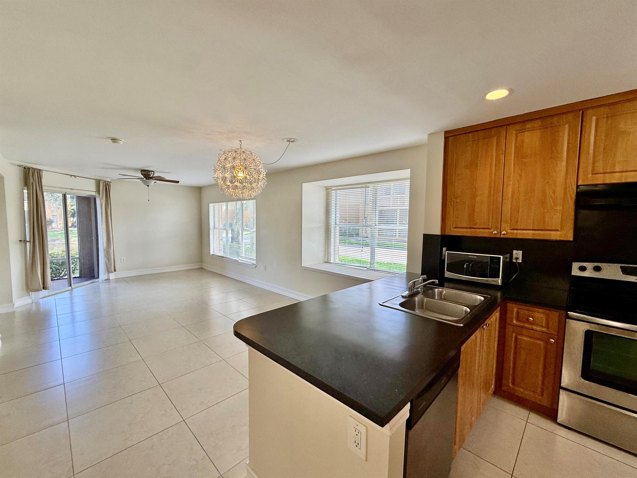 Welcome to 4855 Via Palm Lakes #912 -- where comfort meets convenience in this serene, lakefront corner-unit condo.This spacious two-bedroom, two-bathroom residence is ideally located on the ground floor, offering easy access and enhanced privacy with tranquil views of the water. Natural light pours through large windows, highlighting the open layout and airy ambiance throughout.The kitchen features stainless steel appliances, complemented by modern lighting, ceiling fans, and low-maintenance tile flooring.