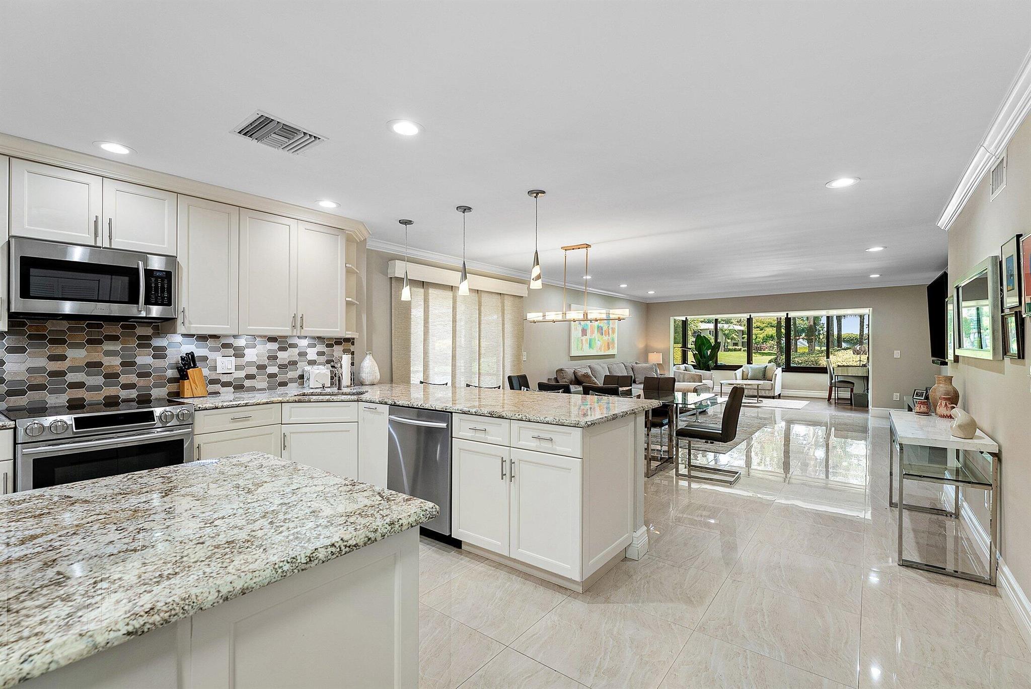 Experience luxurious living in this beautifully renovated 1st floor corner condo, ideally located just steps from the subdivision pool in the highly sought-after Hunters Run Country Club -- where every day feels like a vacation. This light-filled, open-concept home features an elegant, eat-in kitchen with a breakfast bar peninsula and premium finishes, flowing seamlessly into the spacious great room. Crown molding, custom lighting and gleaming tile flooring extend throughout. The guest bedroom is equipped with a convenient Murphy bed. Enjoy indoor-outdoor living with a screened-in side patio, plus an open rear patio offering breathtaking views of rolling hills and the South golf course. A separate side patio with electrical hook-up offers dedicated golf cart storage. 2023 A/C. Newer roof.