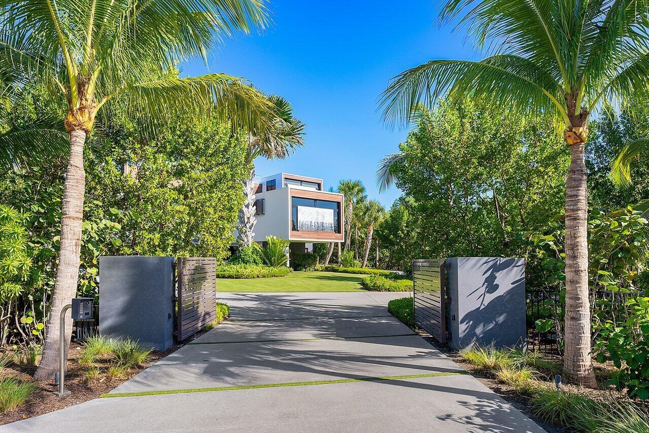 This extraordinary oceanfront property, located on sought after Hutchinson Island, offers a combination of modern design and practical luxury. Situated on a 2.3+ acre double lot in the gated neighborhood of Galleon Bay, it provides an impressive 239 feet of unobstructed oceanfront, making it a highly coveted and picturesque location. The home's contemporary design, completed in 2019, seamlessly blends aesthetics with functionality, and from the moment you step inside, a two-story glass wall on the second floor offers breathtaking views of the Atlantic Ocean. Not only does this house exude modern luxury, it provides unparalleled security and privacy.