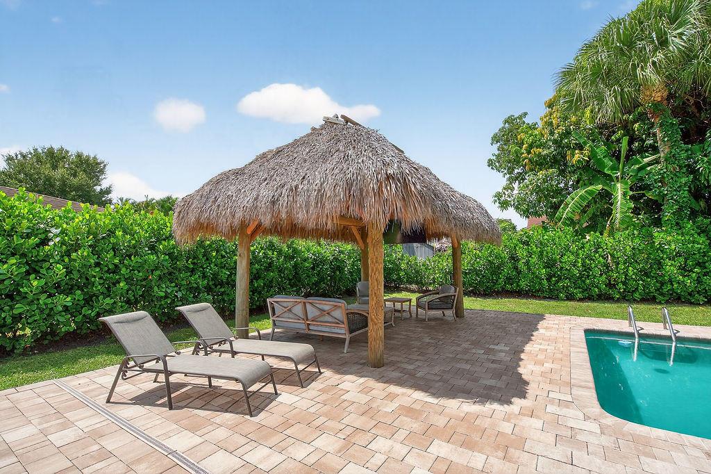 Beautifully renovated 3/2 pool home with 1 car garage in Palm Beach Gardens. Fabulous large fenced back yard, pool with large pool deck, Tiki Hut with electric and big screen TV. Available fully furnished, turnkey or vacant for Annual rental only, pool & lawn maintenance included in rent. The light & bright kitchen has been completely redesigned with white shaker cabinets, quartz counters, custom floating shelves & GE appliances. Both bathrooms received a complete makeover with a walk-in shower in the master, tub in guest bath. Vinyl plank flooring stretches throughout the living space & accented by designer tile in the Florida room & laundry room. All windows are impact glass & for added peace of mind a whole house Generac gas generator & tankless gas water heater.