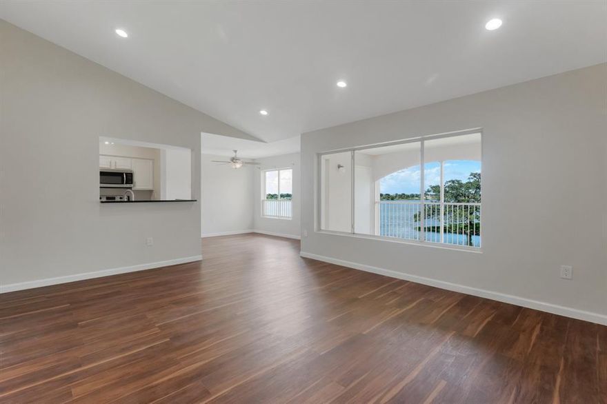 Beautifully updated top-floor corner residence featuring 2 bedrooms and 2 bathrooms with stunning lake views. This premier unit offers vaulted ceilings, recessed lighting, newer granite countertops, stainless steel appliances and stylish newer vinyl flooring throughout. Additional upgrades include newer A/C unit and hot water heater for added peace of mind.  Enjoy the spacious screened-in lakefront patio with a private storage closet, plus the convenience of a full-size washer and dryer inside the unit.  Located in a quiet gated community, residents enjoy resort-style amenities including a pool, hot tub, fitness center, newly updated tennis/pickleball courts, abundant parking, and beautifully maintained grounds with mature trees and lush landscaping.  This pet-friendly community is also a Certified Wildlife Habitat set on 50 scenic acres with a peaceful park-like atmosphere.  Ideally situated near I-95, shopping, dining, and only minutes from the beach. Come see your new home today!