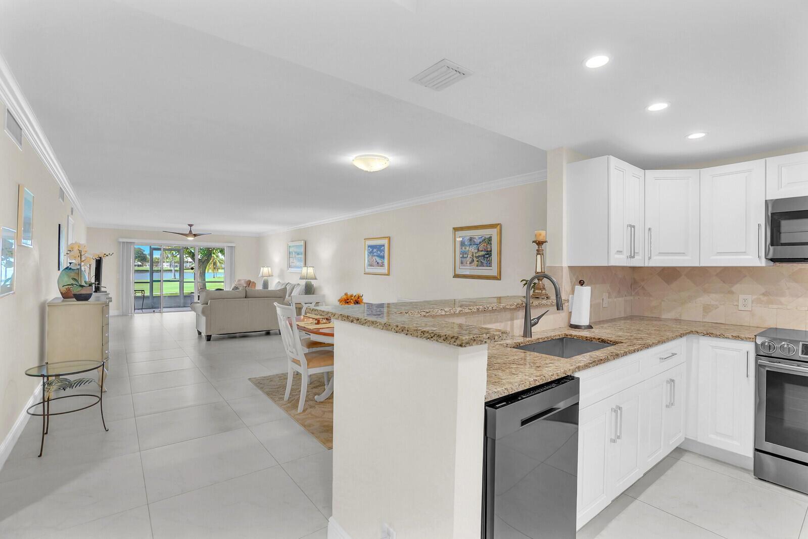 Beautifully renovated 3 bedroom condo located on the golf course in Atlantis, FL. This ground floor corner unit has amazing views of the lake and golf course. Close to I-95, shopping, fine dining and JFK hospital. Community offers amenities such as pool, tennis, pickleball, golf and so much more. This condo has an open concept floor plan with plenty of impact windows that allows natural lighting through-out. Sliding doors leading to the outdoor patio from the living room make this home great for entertaining. Master bedroom is nice size with a walk-in closet and sliding door to the outdoor patio. Master bathroom has marble countertops and beautiful cabinetry. Kitchen has granite countertops, solid wood cabinetry that has ample storage to meet your needs and high end black SS appliances