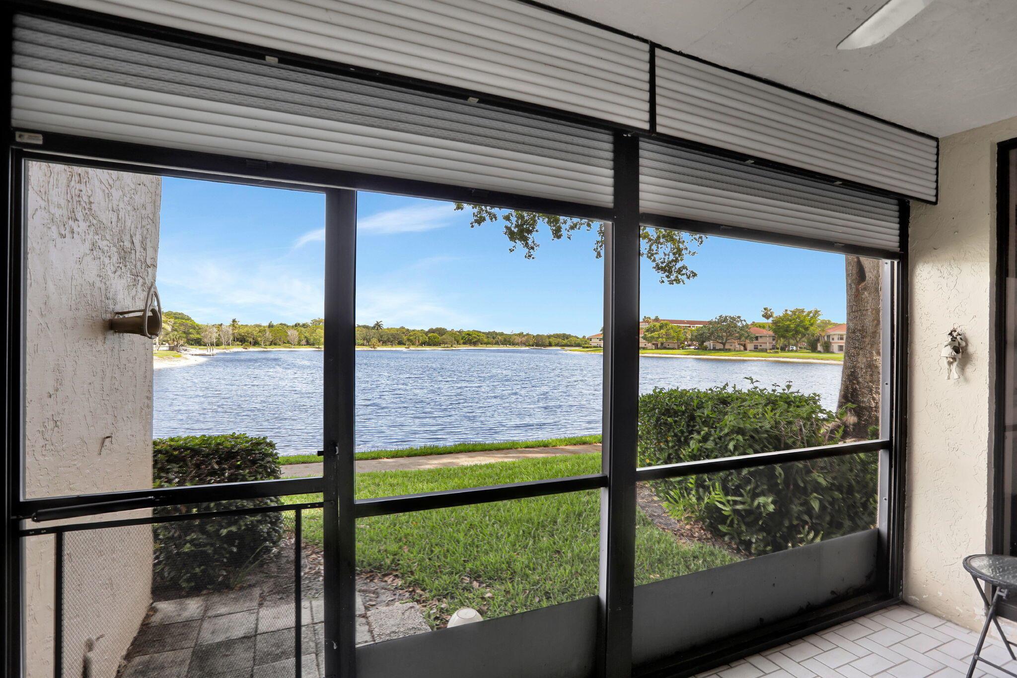 Featured home in the township parade of homes Saturday June 2025 11-3This beautiful first floor apartment overlooks the lake of Tradewinds Park. From the moment you walk in you can see the breath-taking views of the lake. The entire apartment is renovated, and all appliances have been updated. A linen closet has been added to the hallway. All five closets have been completely built out with shelving and hanging systems. Solid wood doors throughout, as well as hurricane proof front door. Accordian shutters on windows with patio rain shutter. Both bathrooms are renovated. Laminate flooring throughout with tiling in kitchen and bathrooms. The condominium board requires buyers to have a credit score of at least 700 with 15% down.