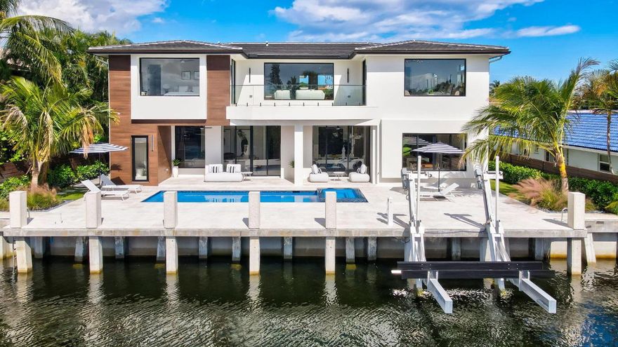 Completed in 2025, this modern waterfront residence offers 84' of deep water frontage, direct ocean access with no fixed bridges, and a private dock with a 20,000 lb boat lift. A marble driveway and refined entry lead to interiors defined by floor to ceiling glass, natural stone, and warm finishes. The great room opens to a resort style waterfront terrace with saltwater pool, integrated spa, outdoor shower, and cabana bath. The chef's kitchen features bespoke European cabinetry, Wolf and Sub-Zero appliances, dual dishwashers, dual zone wine storage, and a hidden walk in pantry. The primary offers spa level luxury with steam shower, sauna, soaking tub, and custom closets. Additional features include whole home automation, security cameras, whole home generator, and a three car garage.