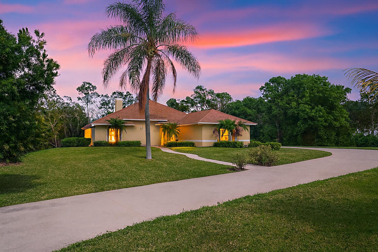 A Rare Acreage Retreat with Room to Breathe and Space to Live the Florida Lifestyle set on a full 2 acres, this 4-bedroom, 3-bath CBS pool home offers the perfect blend of space, comfort, and Florida lifestyle freedom. Inside, a two-sided coral fireplace, vaulted ceilings, and all-tile or wood floors set the tone for stylish country living. The huge kitchen with prep island and stainless appliances and quartz counter tops opens to a bright family room with sliders leading to a screened pool and large covered patio area that is a great entertaining space --your own backyard oasis surrounded by lush tropical landscaping. Enjoy total privacy yet stay minutes from shopping, schools, and Wellington amenities. A fenced dog yard, circular driveway, and 2-car garage make everyday living easy.