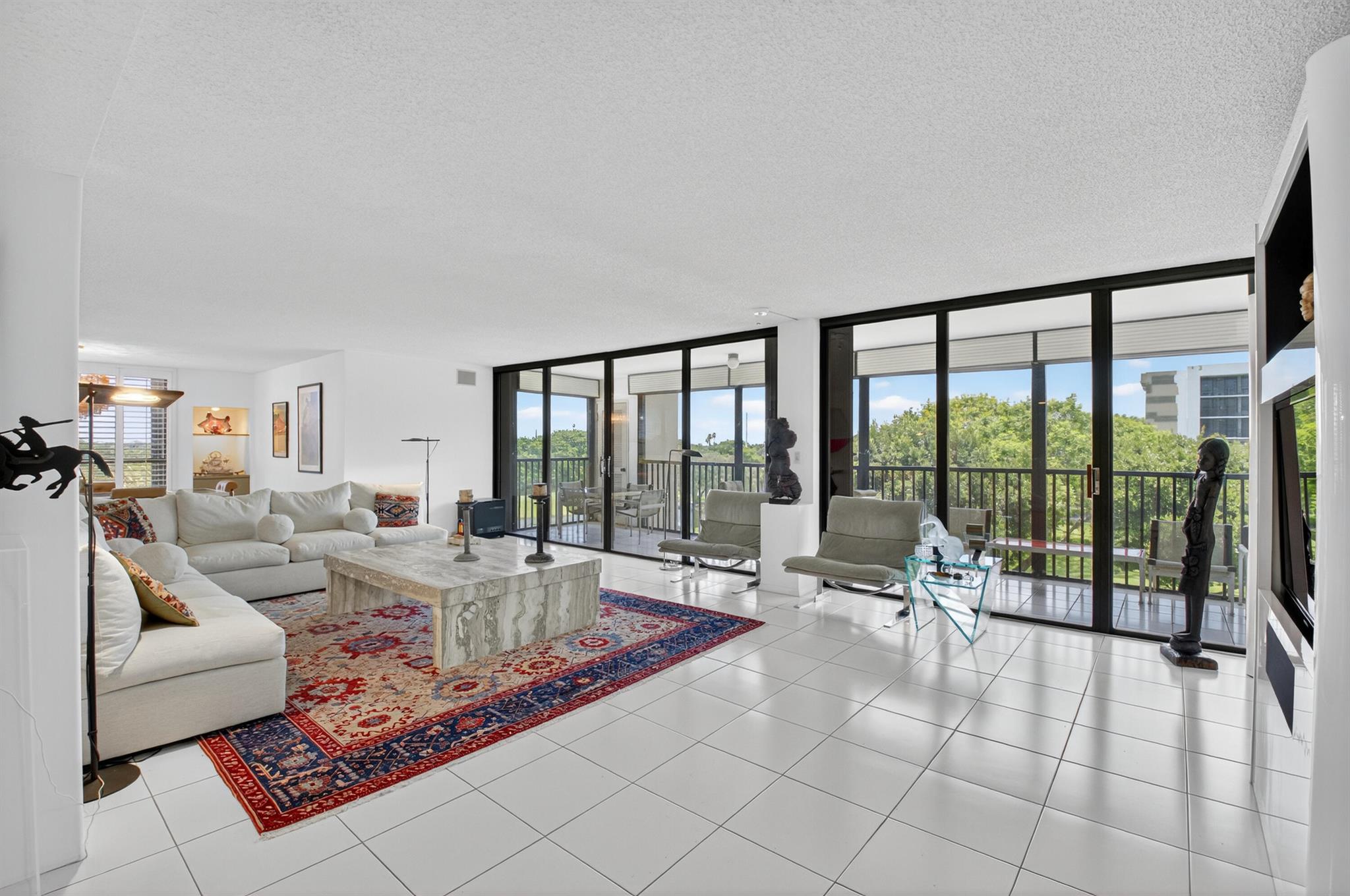 Premium and unique quiet corner location for this 3 BR, 2.5 bath condo with rarely available stunning golf and lake views!!! Third BR opened up for oversized living area-can be closed back. Deeded covered parking, custom built-ins, large screened balcony and full hurricane storm shutters. The building has newly renovated lobby and social room. ~Imagine life inside the Nation's #1 Private Residential Country Club Lifestyle offering resort-style living. PLAY our 4 Golf courses, 27 Tennis courts and 14 Pickleball courts; SHOP our retail store, golf and tennis pro shops, DINE in our 10 dining venues. Spend the day RELAXING at our 5-star fitness center, pool, spa and salon. ENJOY endless activities in over 450,000 sq. ft. of exceptional amenities & stellar service.