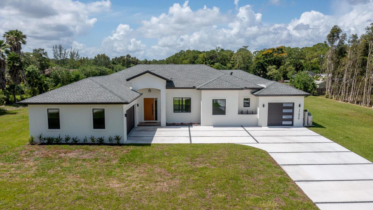 New Construction Estate Home - 4 bedroom, 2 bath, 2 1/2 bath, 3 car garage.Step into the luxurious Loxahatchee lifestyle with this modern home with all conveniences.This is a MUST-see property! Available May 2025.This open floor concept home is perfect for families, friends and entertaining!!'Florida Tropical Paradise' with a large yard for pets, a future pool and large workshop.This home boasts vaulted ceilings, ceiling fans, wood and tile floors with premium baseboards, impact doors and windows, Level 2 EV chargers, tankless electric water heaters and architectural colors. Nicely landscaped.Kitchen has beautiful granite counter tops with tile back splash, clean modern lines of euro cabinetry and stainless-steel appliances.The master bedroom is large and airy with a walk-in