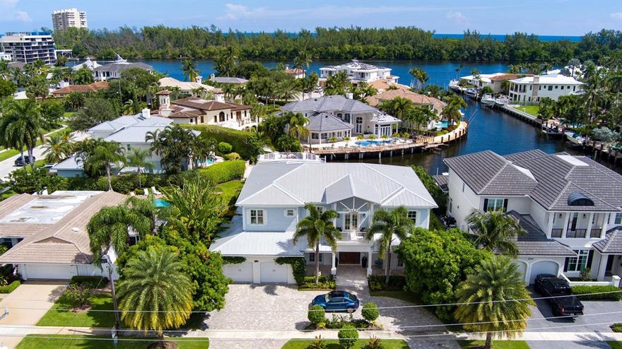 This stunning West Indies-inspired deepwater estate creates a luxurious resort-like realm complete with full-service dockage on 100+/- feet of basin-like waterfront.  Sweeping water views backdrop the spectacular outdoor entertainment space on the tumbled marble terrace featuring a glass-tiled waterfall pool with LED night lighting, a dining lanai with summer kitchen, and a gas fire table.  Lush palms, fruit trees, flower gardens, and an herb garden grace the manicured grounds.