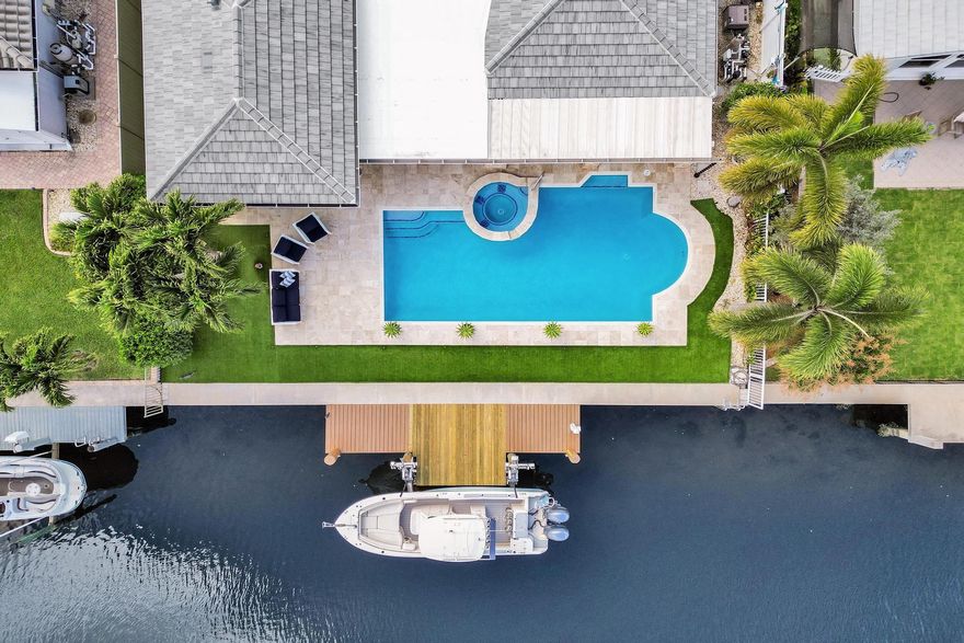 Welcome to this coastal-style gem in highly desirable Garden Isles neighborhood of Pompano Beach. This beautifully renovated 4-bed, 3-bath home offers 70' on the water w/ ocean access, perfect for boating enthusiasts w/ brand new 15,000 lb boat lift. Bright, open interior designed for comfortable South Florida living  featuring updated kitchen w/ SS appliances, gas stove, island & stunning Cristalita Blue marble adding an elegant touch. Recent upgrades incl. new roof, fresh exterior & interior paint, new gutters, lighting, ceiling fans and replumbed heated pool & spa. Fully equipped outdoor kitchen w/brand new outdoor grill, perfect for entertaining. Impact glass thru/out, plantation shutters & so much more. Minutes from beaches, dining, and shopping. A true must see!