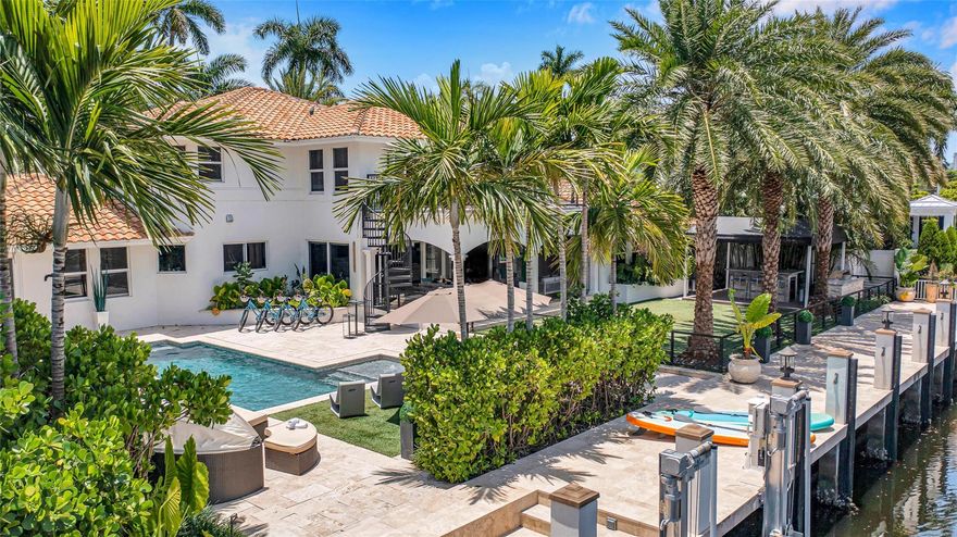 This prestigious home is in the guarded community of Seven Isles. A renovated & stunning waterfront estate with a rare 100' of waterfront off Las Olas Blvd & Ft. Lauderdale Beach. On 1/3-acre, the lush landscaping creates the feel of a private oasis. Inside 4 of 6 bedrooms are suites & a full bath dedicated as a cabana bath. The primary suite has water views & a private balcony. Additional features outside: heated pool, summer kitchen, large turf space & covered lanai. Windows are wind-rated & full home natural gas generator. Dock up to an 80ft yacht, 12k-lb boat lift, direct ocean access no fixed bridges! East-West canals mean a constant sea breeze & wide waterways. The North rear exposure = privacy from high-rise condos creating an unparalleled estate. Currently a cash flowing luxury STR