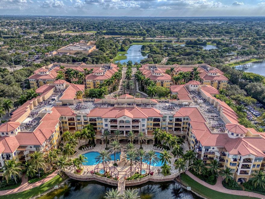 Welcome to this coveted first-floor corner residence in the main building of the guard-gated 55+ community of The Palms at Weston. Featuring higher ceilings and a prime location near all activities and amenities, this 2-bedroom, 2.5-bath condo offers peaceful garden views and a large private balcony. The kitchen boasts wood cabinetry, granite countertops, stainless-steel appliances, and a spacious eat-in area. The open layout includes crown molding, recessed lighting, fresh paint, and laminate/tile flooring throughout. The primary suite offers a walk-in closet, dual vanities, and a separate shower. Enjoy resort-style amenities and the convenience of an on-site Cleveland Clinic, plus proximity to Cleveland Clinic Hospital, major highways, Publix, and dining options.