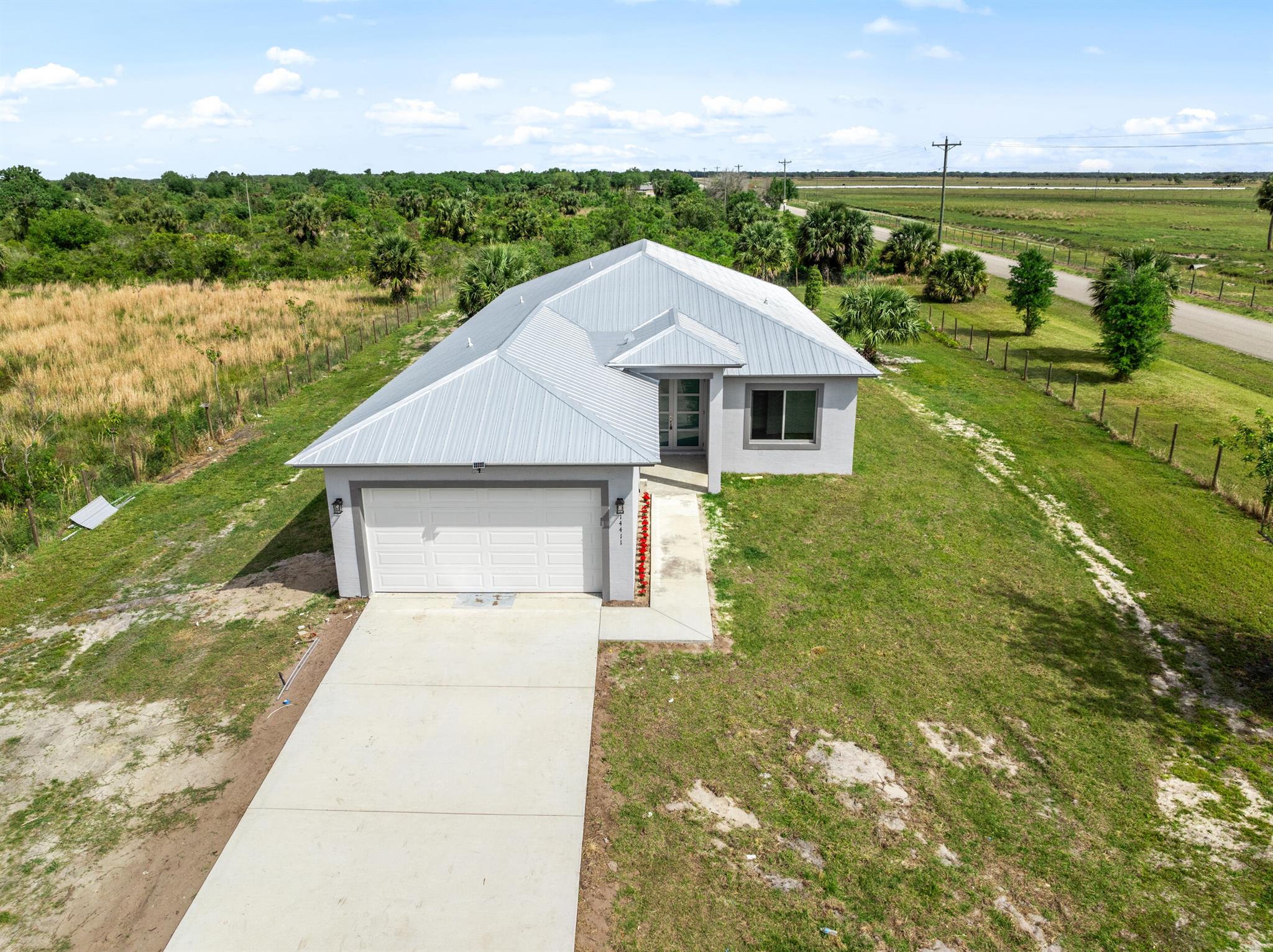 Expect to be Impressed with this corner lot off paved road. Come make this your home today. This new construction house is 3268 total sq. ft. on 1.25-acre fenced lot with no HOA. It offers 4 bedrooms and 2.5 bathrooms with a split and open floor plan. Attached is a 2-car garage and a covered patio. Highlights include brand new 2024 construction with architectural shingles, impact windows, Stainless steel appliances, granite countertops, energy efficient inside/outside central AC system and more. Ample parking. Bring your boat, RV, toys and animals.