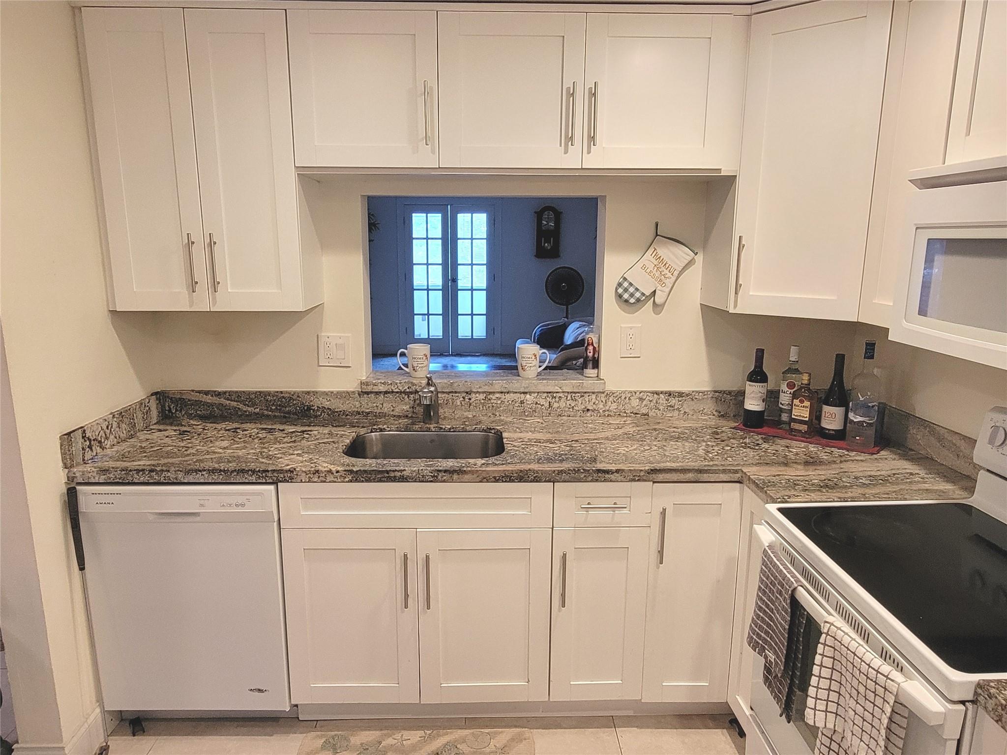 Price to sell ... updated spacious corner unit in a 55+ community! The kitchen is a chef’s dream—featuring granite countertops, solid wood cabinets with designer hardware, deep undermount sink, large pantry, all complemented by quality Amana appliances. Brand-new A/C and water heater (2024) for worry-free living. Both bathrooms shine with upscale finishes, including quality vanities, highboy toilets, and stylish lighting. Enjoy the perfect blend of comfort and style with 24" tile and plush carpet throughout. French doors open to a large, glass-enclosed patio—ideal for morning coffee or evening relaxation. Maintenance includes cable, water, sewer, trash removal, 24-hour security, and a heated pool—everything you need for easy living. Move-in ready and easy to show—schedule your tour today!