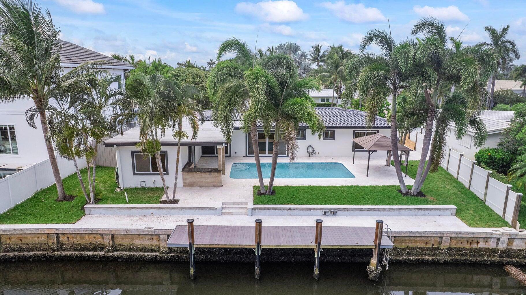Welcome to a one of a kind, stunning, waterfront, modern tropical oasis. 808 NE 72nd Street is a single family home in desirable non HOA neighborhood of Boca Harbor, east Boca Raton. The home features an 80 ft dock with NO FIXED BRIDGES! Bring your boat/yacht and enjoy waterfront living at its finest. Be the first to occupy this recently updated home featuring the finest in modern appointments. 4 bedroom, 3-bath, garage, modern heated-pool, brand new slip-resistant stone deck, new boat dock, neutral wood style flooring throughout the entire interior of home (no carpet at all!), modern kitchen with stainless steel appliances and quartz countertops, a large dining island, updated bathrooms, open floorpan with split and spacious bedrooms (main master bedroom on