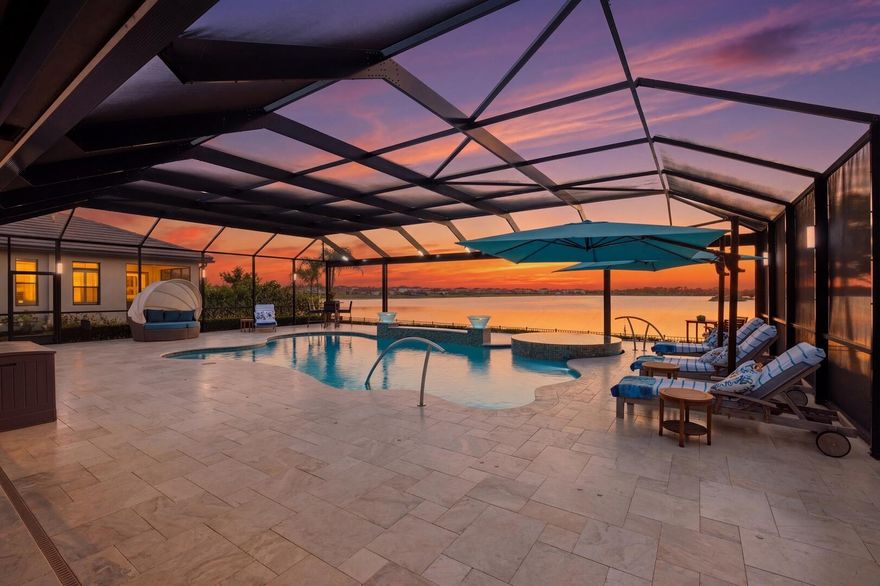 A stunning lakefront pool home designed with a clean, modern edge and elevated finishes throughout. Offering 4 bedrooms plus a sleek study/den and 3.5 baths, the home makes an immediate statement with a dramatic double-door entrance that opens into a grand foyer featuring a striking triple tray ceiling. The main living space is wide open and filled with natural light, anchored by a spacious great room with walls of glass that fully connect indoor and outdoor living. Entertain effortlessly in the formal dining area, all wrapped in smooth walls, crown molding, wood-look plank tile flooring, impact windows, and plantation shutters. You also have the peace of mind of a whole-house generator and a full water purification system already in place. The kitchen is straight out of a design magazine—crisp, modern, and highly functional. Quartz countertops, a clean tiled backsplash, stainless steel appliances, a 5-burner gas range with vented hood, oversized island, and casual breakfast nook all come together in a space that's built to impress.  The primary suite is a private escape with a tray ceiling, dual walk-in closets, and a spa-style bath featuring a freestanding soaking tub and a glass-enclosed walk-in shower.  Outside is where this home really separates itself—your own resort-style setting overlooking the water. A custom saltwater heated pool and spa with 6 jets, marble decking, full screen enclosure, and a fully equipped summer kitchen with top-of-the-line appliances create a seamless outdoor lifestyle that feels like a private retreat.  Finished off with  Polyaspartic garage flooring and a premium lakefront setting, this home is dialed in, move-in ready, and built for the way people want to live today.  Located within walking distance to the new elementary school and near top-rated K-12 options, this home offers convenience as well as luxury. The community provides resort-style amenities: miles of trails, two clubhouses, pools, pickleball, tennis, basketball, boat ramp, fishing piers, skate park, dog parks, and even a working farm offering organic produce to residents.