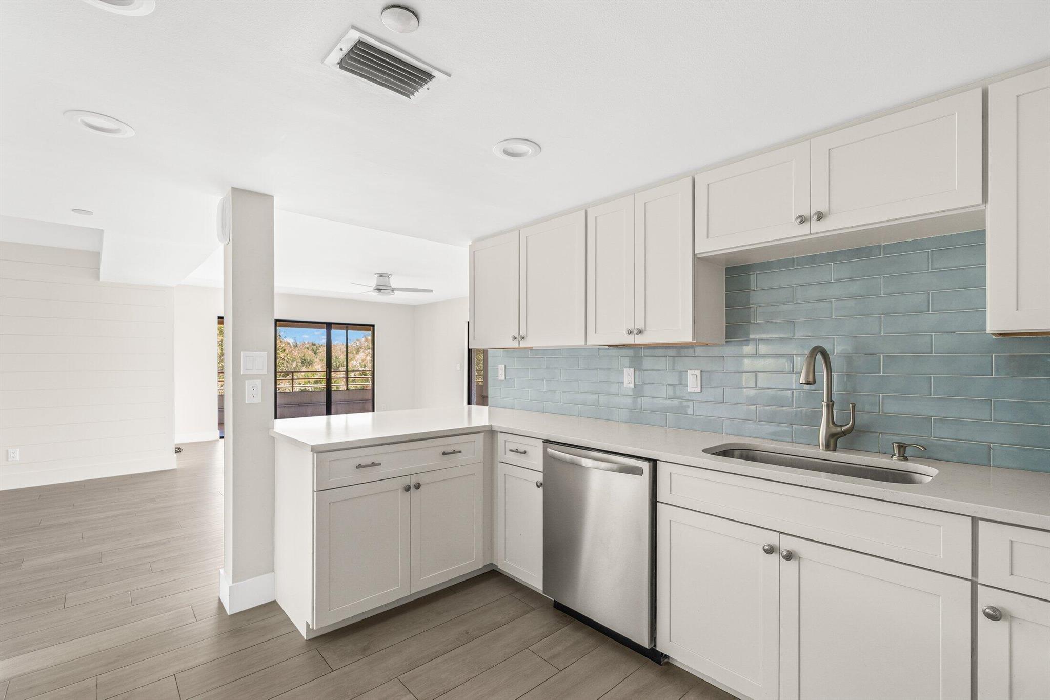 This beautifully renovated corner unit boasts a spacious kitchen, 3 bedrooms, and 3 baths within the charming intercoastal community of Oak Harbor. Positioned on the top floor, it features an expansive wrap-around balcony, rare attic storage, and stunning views of the oak trees. Floor-to-ceiling sliders fill the space with natural light, highlighting breathtaking golden sunsets in the evenings. Newly installed flooring, shiplap walls, a modernized kitchen with new appliances, updated bathrooms, and contemporary fixtures mean it's move-in ready. Centrally located in the tranquil gated community of Oak Harbor in North Palm Beach.The Marina community offers a large waterfront clubhouse complete with a fitness center, swimming pools, and tennis court