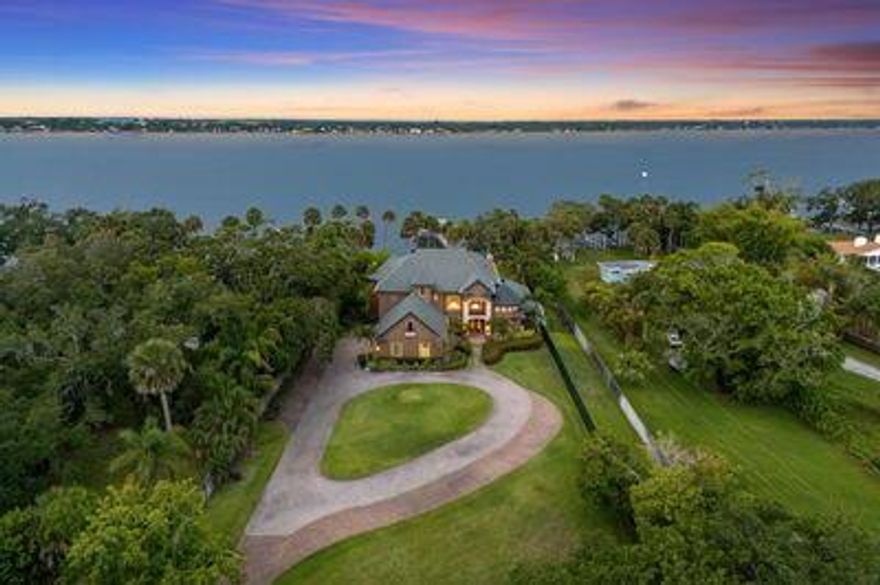 Tucked on 2.86 acres with 118' of deep Intracoastal frontage, this private Merritt Island estate offers rare scale, seclusion, and water access. A gated compound with two parcels, 5,500+ SF home, and oak-lined drive, it features solid wood floors, a chef's kitchen with granite island, impact windows, and indoor-outdoor flow to a heated pool, spa, and lanai. Enjoy a guest suite, office, lounge, finished attic, and primary suite with water views. Extras include 5 HVACs, Generac generator, whole-home audio, air-conditioned 3-car garage, and lush grounds irrigated by artesian well.