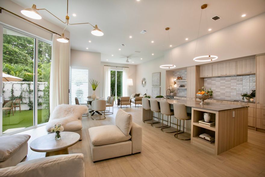 Step into refined living with this completely transformed home SOLD FULLY TURNKEY - FURNITURE, ART, KITCHENWARE - on a corner lot in the prestigious Ballenisles Country Club community. Move right in to this exceptional designer home. This 3 bedroom residence offers 3 ensuite baths, providing privacy and elegance in a completely redesigned and open floorplan. Twelve foot ceilings throughout create openness and volume, as you enter through 10-foot tall double doors into a newly expanded sunlit living area - featuring 10-foot windows now extending to the floor. With an expansive set of sliding glass doors allowing natural light, one's connection to the backyard sanctuary is enhanced. THE ENTIRE home is secured with newly installed hurricane impact windows and doors, dressed in custom drapes and plantation shutters. the garage has a new impact garage door and opener. Custom kitchen features brand new KitchenAid appliances, extensive pantry space, an induction cooktop, wall oven/microwave combo and a massive island topped with a dramatically veined gray quartz. A seamlessly integrated bar anchors the heart of the home, complete with a built-in wine/beverage fridge - perfectly positioned between the kitchen and all the entertaining spaces. The look extends into the newly expanded laundry with a stainless sink, beautiful cabinets and a brand-new LG washer and dryer - elevated on pedestal drawers for extra storage and easy access. The Primary suite has been redesigned to include a custom built-in closet and a luxurious free standing bath tub featuring a picture window overlooking a private garden. The backyard sanctuary features maintenance-free turf grass and landscaping within privacy walls trellised in jasmine and newly planted palm trees. The roof was installed in 2021 and is now sealed with "Rhino Roof" coating, enhancing protection and extending its lifespan. Spray foam insulation fills the attic creating a sealed space overhead for dramatic energy efficiency, allowing the new AC system to deliver efficient climate control with low energy bills. Welcome to Ballenisles County Club and your opportunity to become a member - enjoying the amenities of a 5-Star Platinum Rated Club and live the Florida Vacation lifestyle. (Golf membership available.)