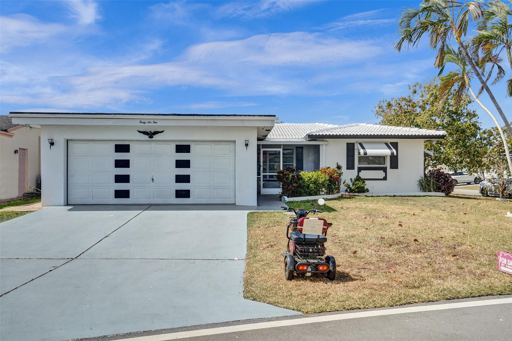 Welcome to your BEAUTIFUL home in the Mainlands of Tamarac, a vibrant 55+ community! This stunning corner lot property boasts an updated kitchen featuring newer appliances, complemented by ceramic and wood flooring throughout. Enjoy the screened-in porch and panoramic views of the lush surroundings. The large 2-car garage offers ample storage and convenience. Key updates include a 2004 AC unit and a 2021 water heater, ensuring comfort year-round, and den can be converted to a third bedroom. The roof features two coats of rubber for added durability, and protective shutters provide peace of mind. Embrace a laid-back lifestyle, and come make this home your very own.