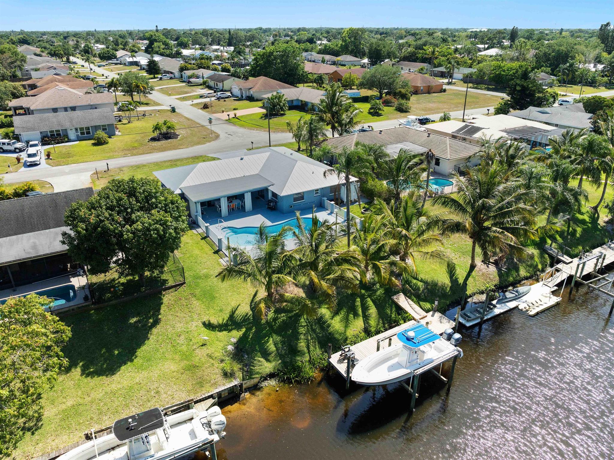 Welcome Home to this Beautiful Lovingly maintained CBS 3/2/2 Pool home with Ocean Access. Just bring your boat and furniture to this impeccable updated beauty featuring a New roof, HVAC and ductwork in 2024. Inground salt water pool was resurfaced in 2023. Outdoor shower. Well maintained dock complete with a 12000 LB Lift. Accordion Hurricane shutters. Sprinkler System. Private Covered Porch overlooks the fenced salt water pool and canal with beautiful Coconut Palms. Owners suite, Dining Room and Family Room have Sliding Glass Doors leading to the Covered Porch. The Owners suite features tile flooring , a beautiful new Bathroom and large walk in closet complete with built ins.Tile flooring in the main living areas. Beautifully remodeled Hall Bath. Split Floor Plan. Appliances included
