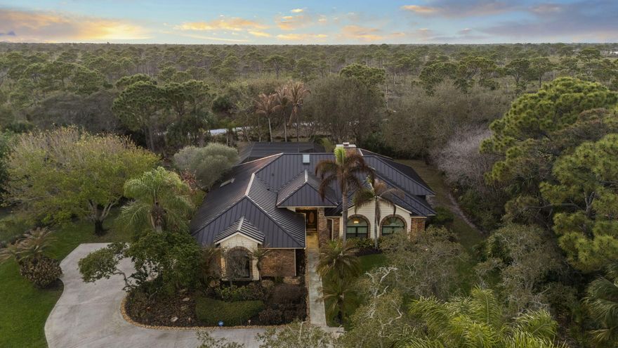 Rarely available home in the intimate estate community of Sugar Hill, known for its rolling hills and oversized estate lots. Situated on 1.026 acres of beautifully landscaped property, this charming 4-bedroom, 3-bath pool home offers privacy and character throughout. The property backs directly to the Savannas Preserve for a peaceful natural backdrop. Newer metal roof and impact windows provide peace of mind. Inside features a spacious living room with a floor-to-ceiling brick fireplace, plus separate family and dining rooms. The expansive primary suite offers tray ceilings, updated bath, and French doors to a screened patio with heated pool and summer kitchen. Located in a sought-after school district, just minutes to beaches, dining, and shopping.