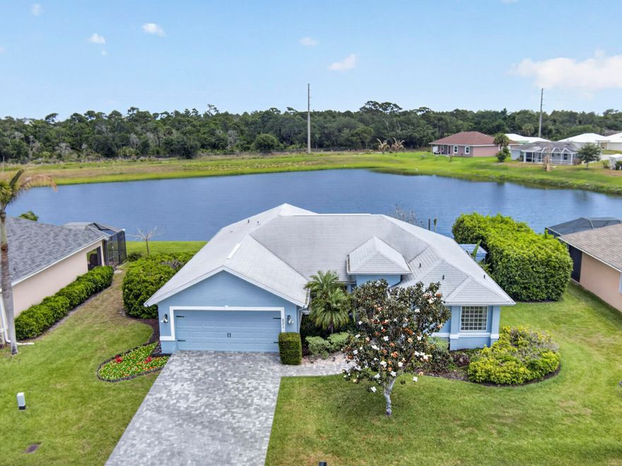 Located in the gated community of High Hawk, this 3BR/2BA concrete block home offers 2,248 sq ft with serene lake and preserve views. Open, split floor plan with vaulted ceilings and spacious living areas. 1 of only 6 lakefront homes in the neighborhood offering exceptional privacy. Recent upgrades include 2021 roof, new paver driveway (2025), whole-house water filtration, garage AC (2025) and utility shed. Garage converted to AC space (billiards room) could easily be converted back. Peaceful community with newly paved roads, close to shopping, dining, and beaches.