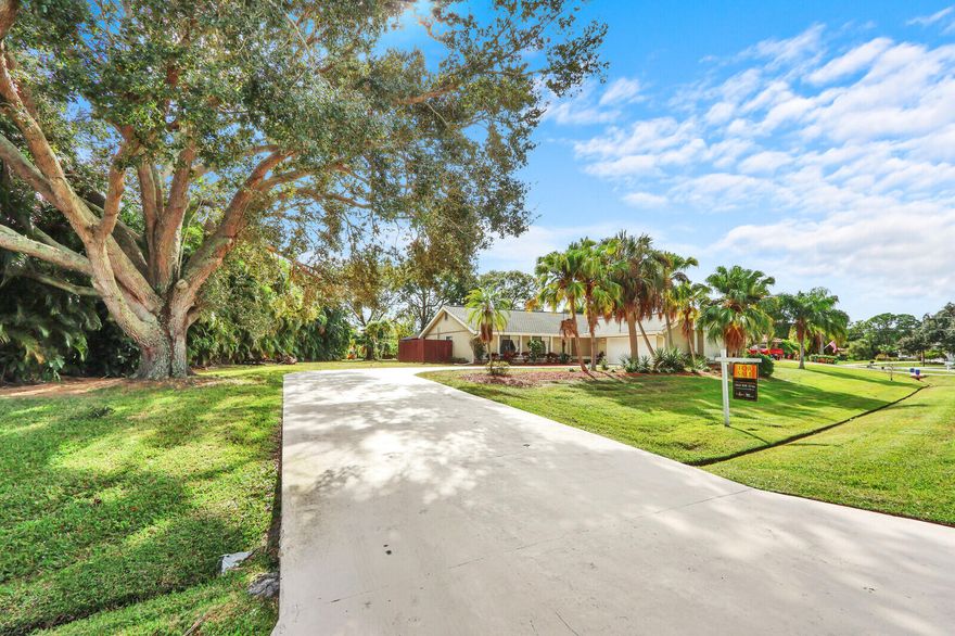 Opportunities to own a pool home on a HALF-ACRE lot in Port St. Lucie are increasingly rare, especially in the heart of coveted Sandpiper Bay! With no HOA, this property offers exceptional space, privacy, and endless possibilities for outdoor living, future enhancements, discreet storage for a boat or RV, or simply the luxury of elbow room. The beautifully renovated interior is designed for effortless living and comfortable entertaining. Natural light pours through wide French doors, illuminating the open great room and enhancing the home's bright, connected layout. Anchoring the space is a crisp white kitchen featuring granite countertops, a generous center island, Frigidaire stainless steel appliances, deep drawers, and bar seating that easily transitions from casual mornings to relaxed gatherings. The spacious living area opens to a screened lanai with a crystal-blue pool and covered patio, creating an inviting extension of the home that can be enjoyed year-round. A flexible den with an ensuite bath and private entrance offers excellent versatility as a home office, flex space, or small guest suite. The owner's suite provides a comfortable retreat with double closets and a beautifully renovated bath featuring dual sinks and a frameless tile-surround shower with a built-in bench.  An attractive scalloped architectural shingle roof adds both durability and character. Ideally located just minutes from riverfront parks, golf, dining, and area beaches, this property delivers privacy, land, and style without HOA fees or restrictions. Offered at $600,000, the renovations, pool, half-acre homesite, zero HOA, and move-in-ready condition set this property apart from the rest of the market.